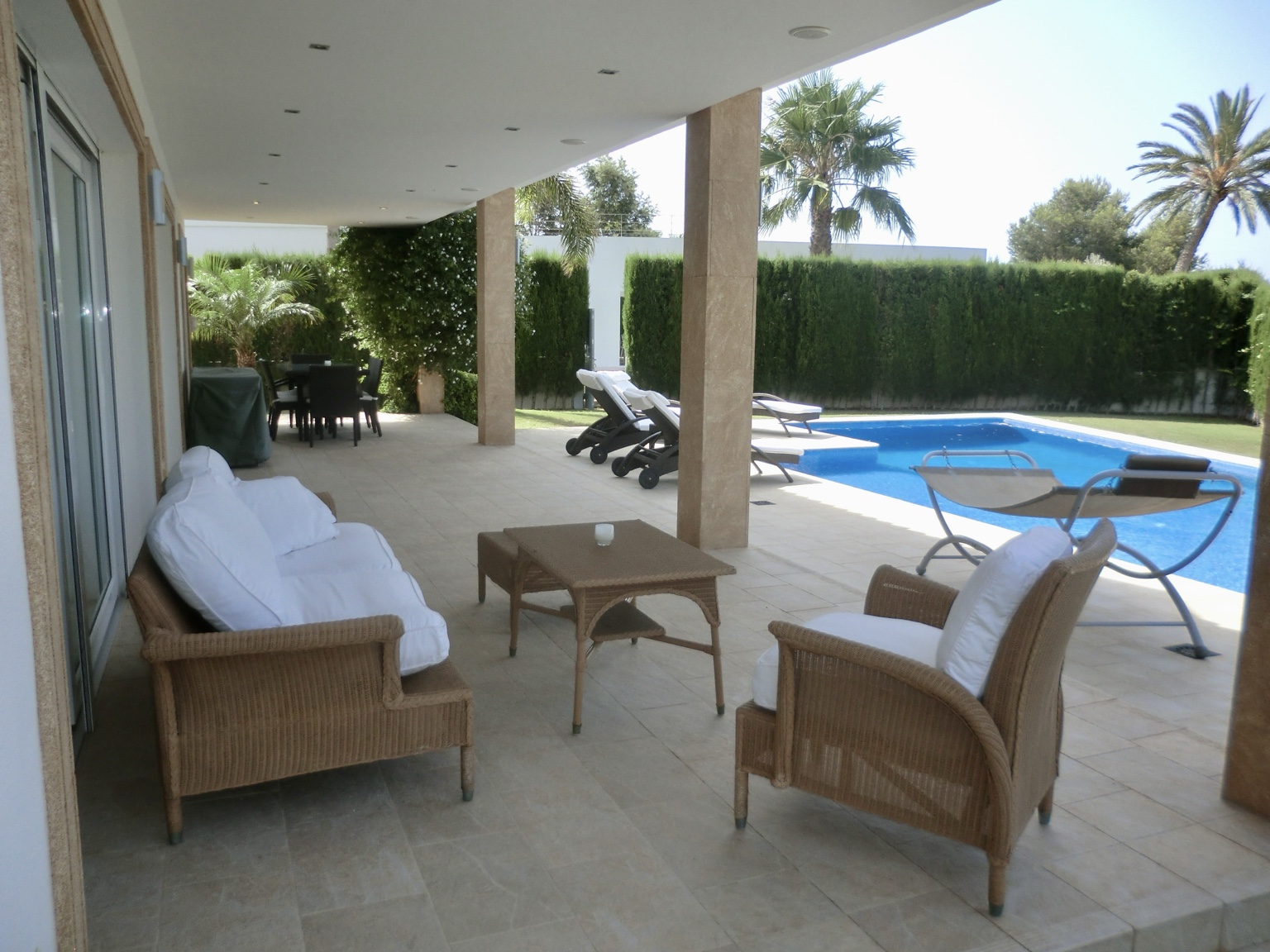 Covered finca terrace beside a swimming pool